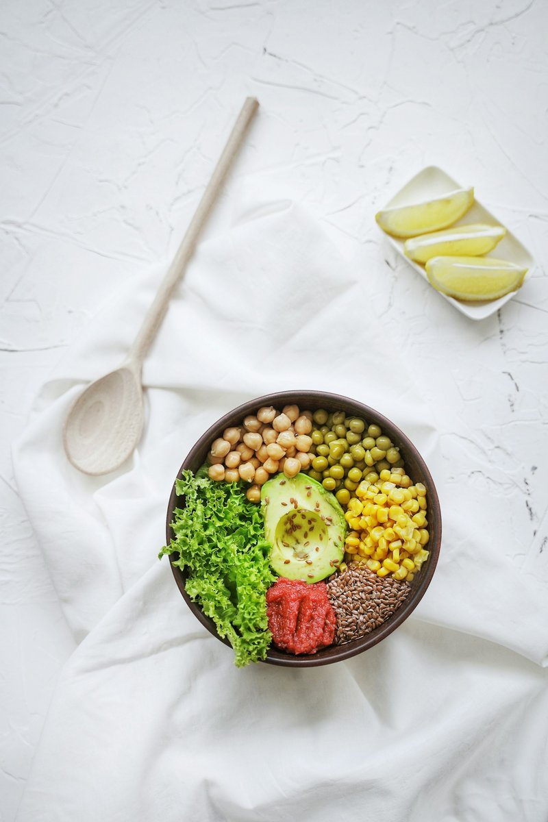 Bol de pois chiches, lentilles, maïs, avocat et salade