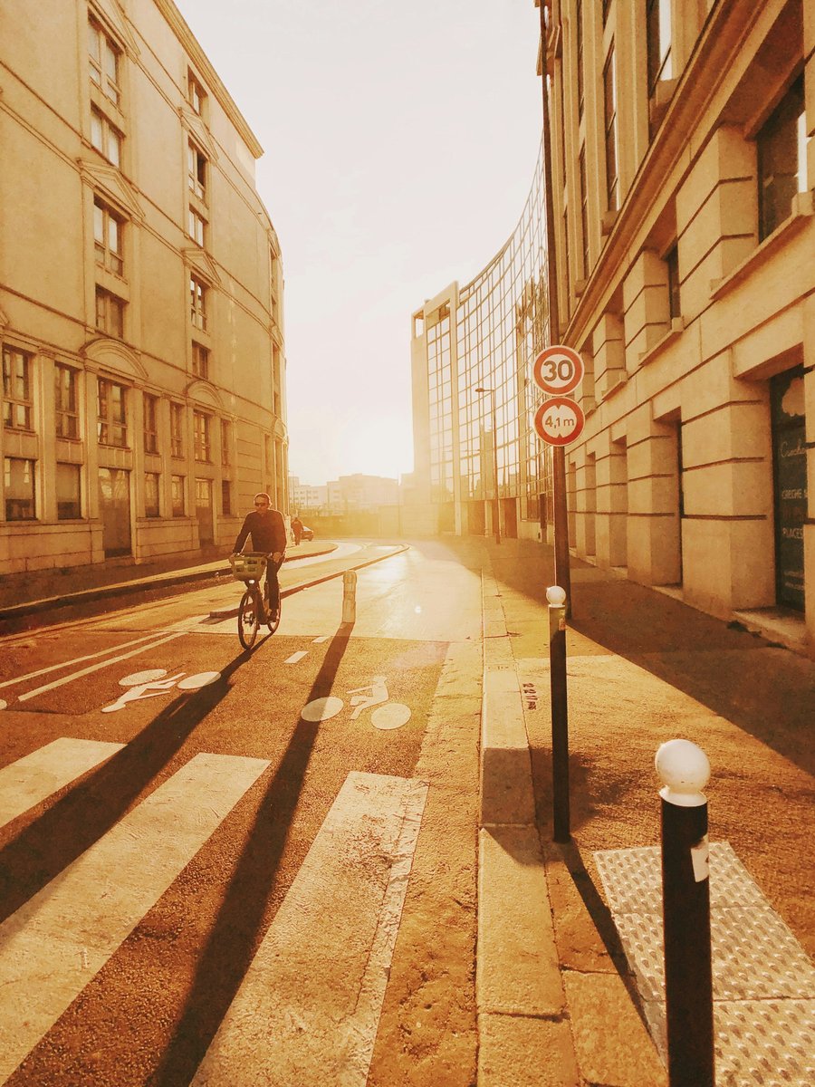 Cycliste au loin dans une rue au soleil couchant